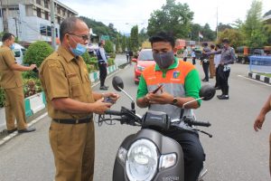 Sekda Erizon, Bagikan Masker Kepada Salah Seorang Pengendara di Jln. Ilyas Yakub, Painan