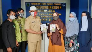 Pembina Ruang Kreatif Hamasah Imratul Handayani Menyerahkan Buku Like a Need Joke Kepada Kepala Dinas Kominfo Padang Panjang Ampera Salim